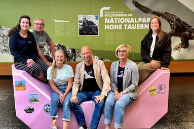 Sechs Personen sitzen und stehen rund um den rosa Enzi. | © Ferienregion Nationalpark Hohe Tauern
