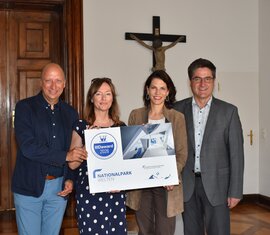 Vier Personen präsentieren den IIID Award 2026 der Nationalparkwelten. | © FNPHT